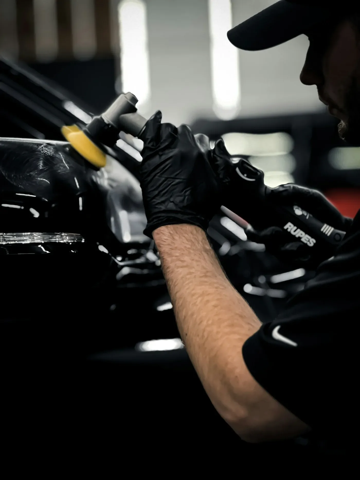 Fahrzeugpfleger arbeitet an einem Auto in der Werkstatt